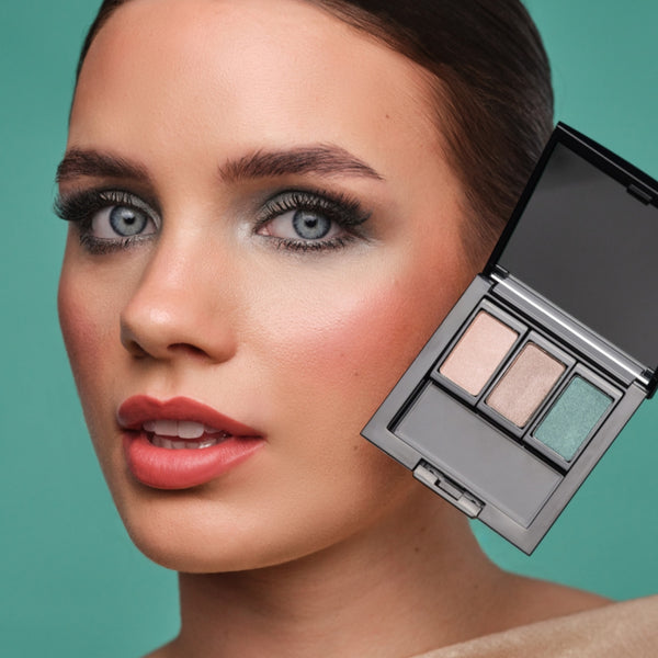 Model mit intensivem Abend-Make-up in Grün- und Taupetönen hält eine befüllte Beauty Box.