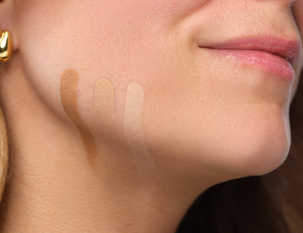 Drei Foundation-Nuancen werden auf der Wange aufgetragen, um die passende Farbe für einen natürlichen, ebenmäßigen Teint zu bestimmen.