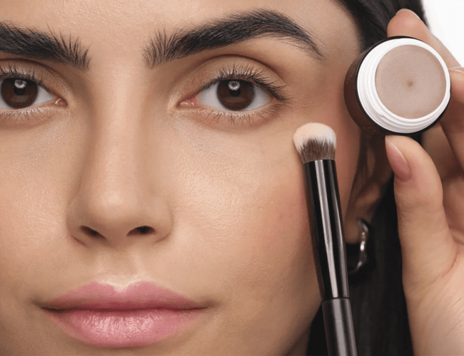 Model bereitet das Augenlid mit einer Lidschatten Base vor und fixiert sie anschließend mit Puder als Grundlage für Smokey Eyes.