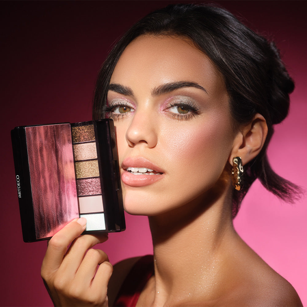 Hand hält ARTDECO Glittery Eyeshadow Palette 4 vor festlichem Make-up-Look