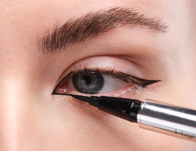 Weiße Pfeile zeigen an, wie man für den Cat Eyeliner den inneren Innenwinkel schminkt.