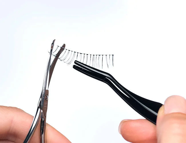 Die Bandwimpern werden mit einer Schere auf die richtige Größe angepasst