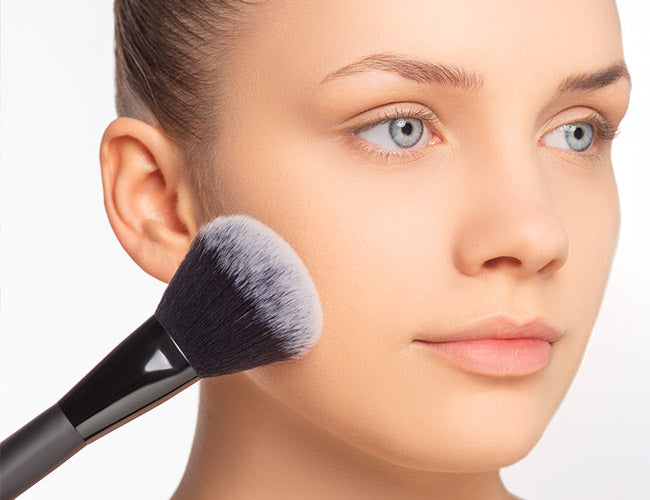 Mit Hilfe eines Puder Pinsels wird Fixierungspuder aufgetragen