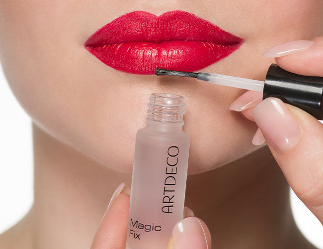 Roter Lippenstift wird mit dem Magic Fix für eine längere Haltbarkeit versiegelt