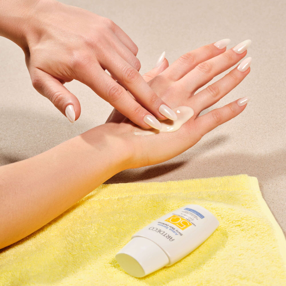 Aqua Serum Daily Defense SPF50+ wird auf der Hand aufgetragen und mit zwei Fingern eingearbeitet