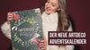 Ein Model in rotem Outfit präsentiert den weihnachtlich gestalteten ARTDECO Adventskalender. Verschiedene Aufnahmen zeigen den limitierten Kalender, Geschenkboxen und Beauty-Produkte in festlicher Atmosphäre.